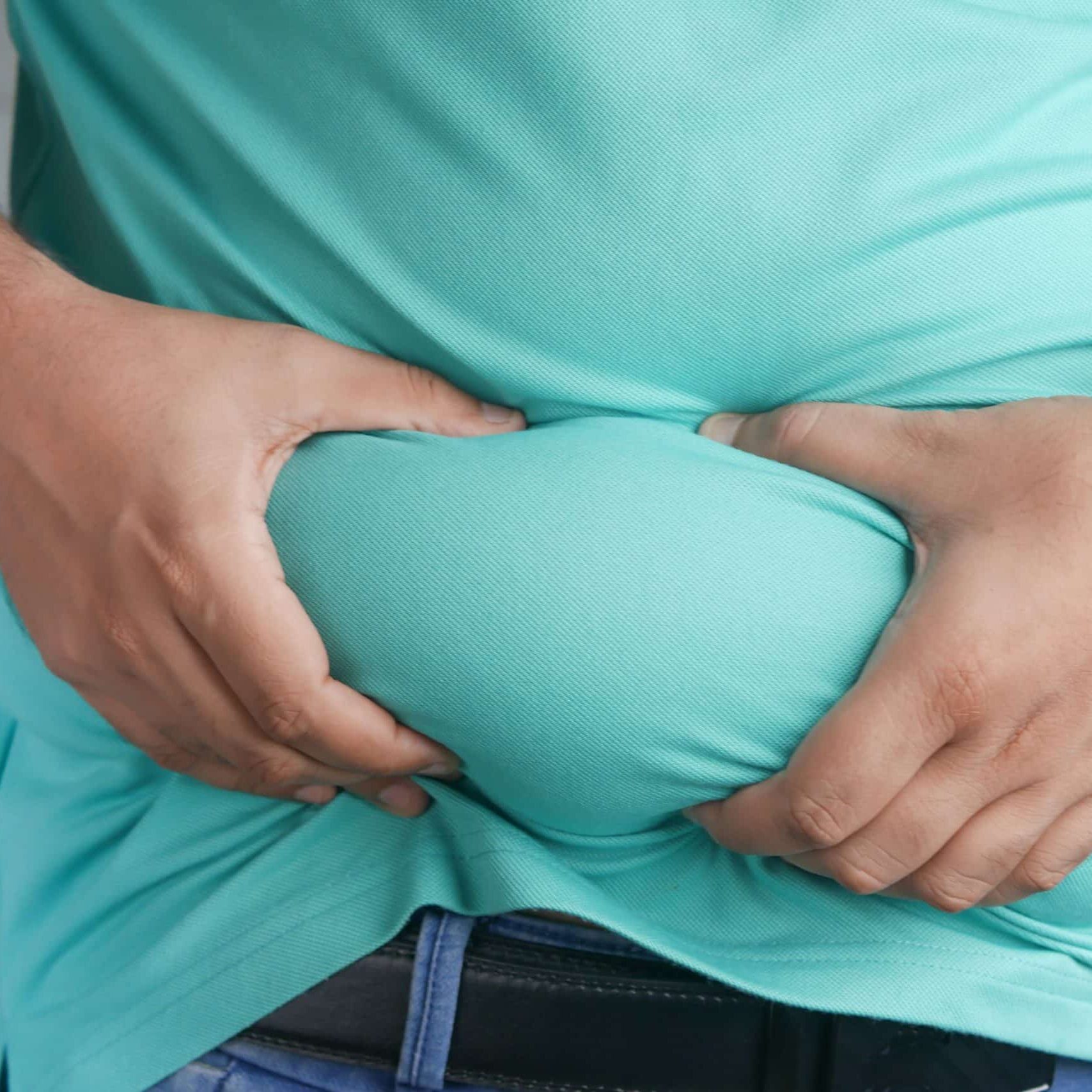 overweight person grabbing belly fat