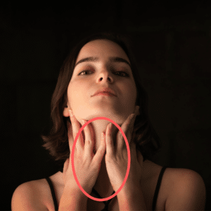 A woman holds her throat wanting to know how to treat acid reflux naturally.